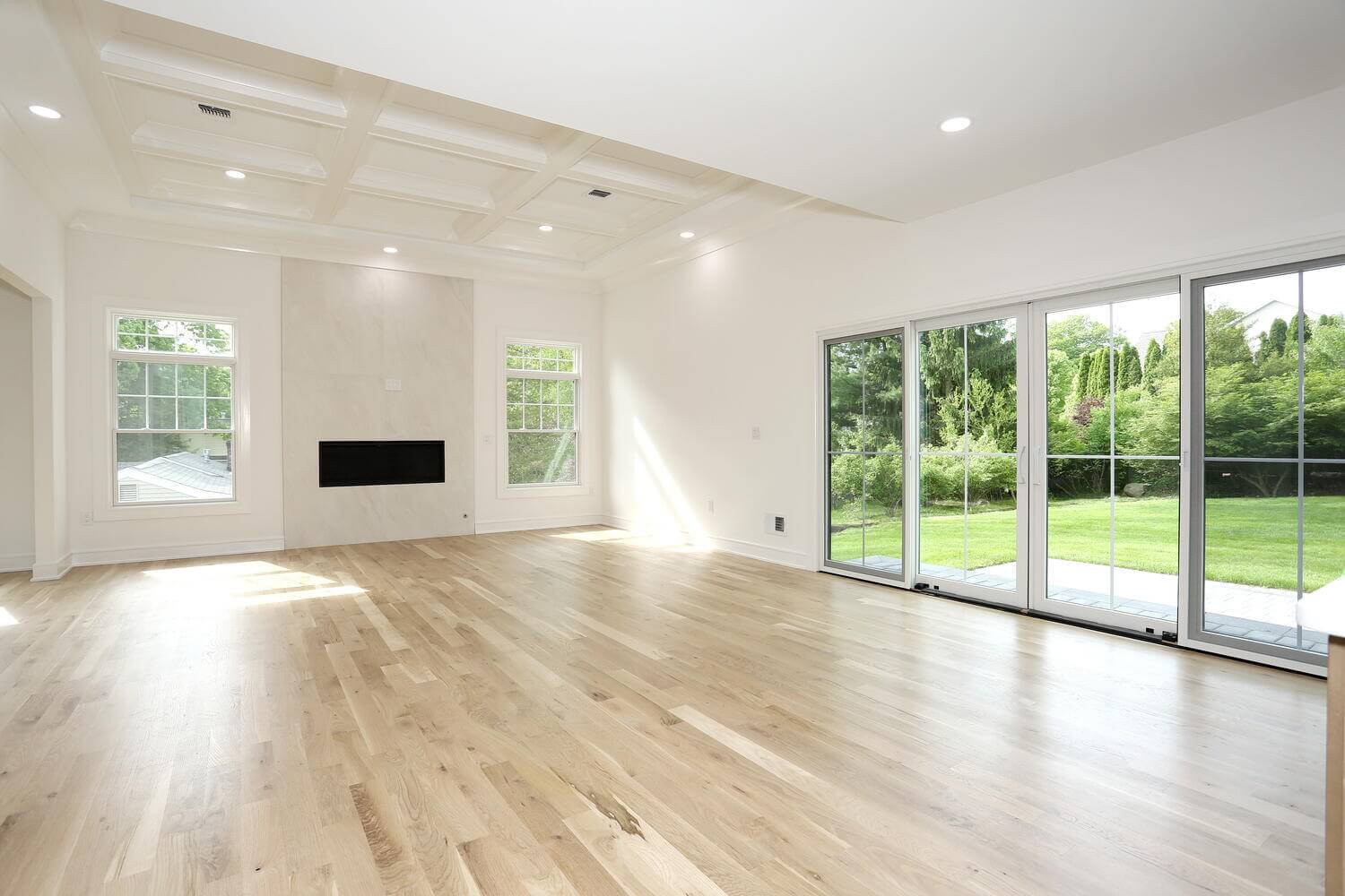 Family room with fireplace and sliding glass doors opening to the exterior, built by Dadak LLC in Park Ridge NJ