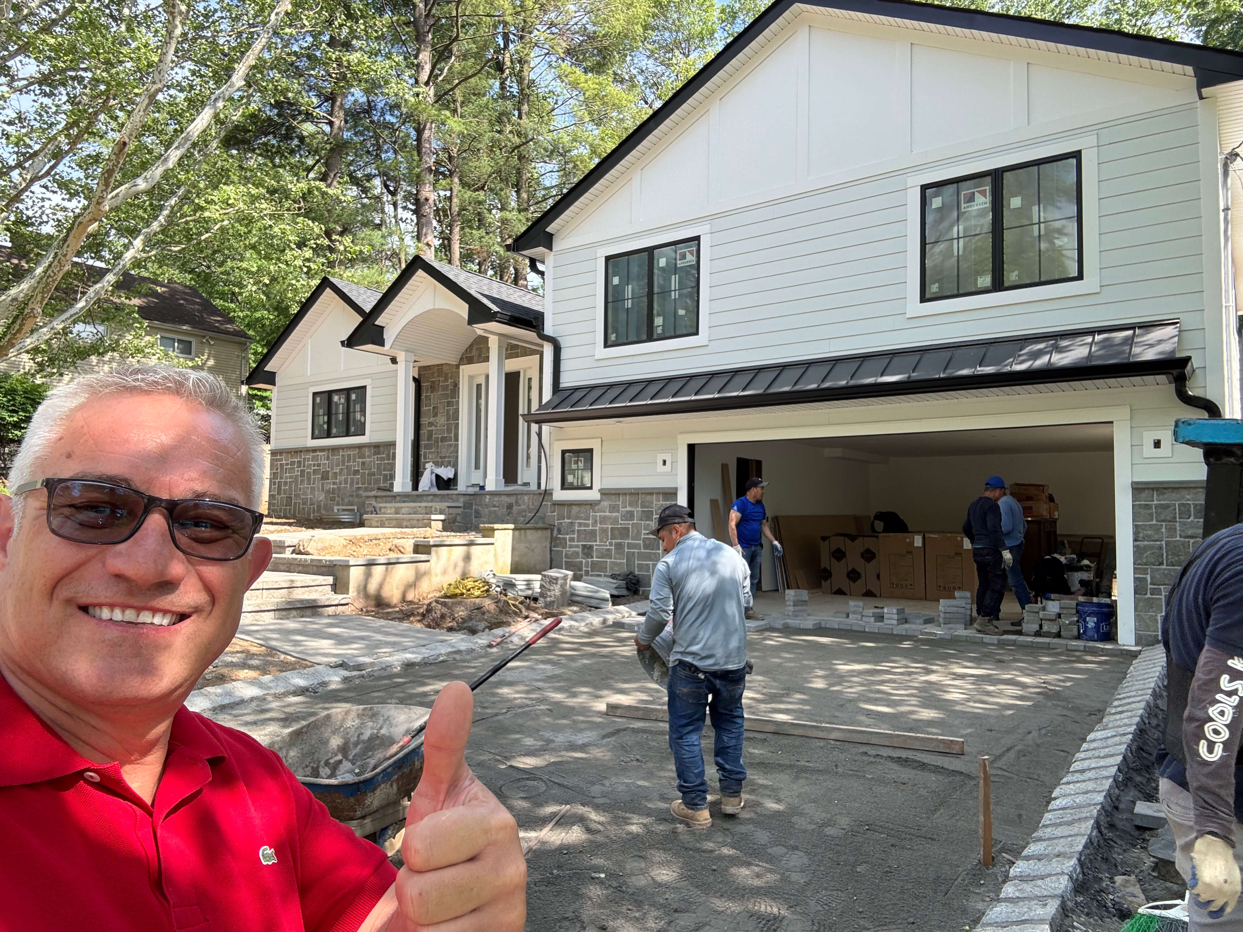 Dragan Dinic giving thumbs up in front of a newly completed custom home in Hillsdale, NJ built by Dadak LLC